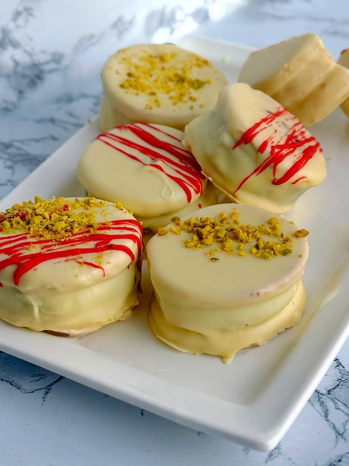 White chocolate alfajores with pistachio and red chocolate drizzle in Playa del Carmen